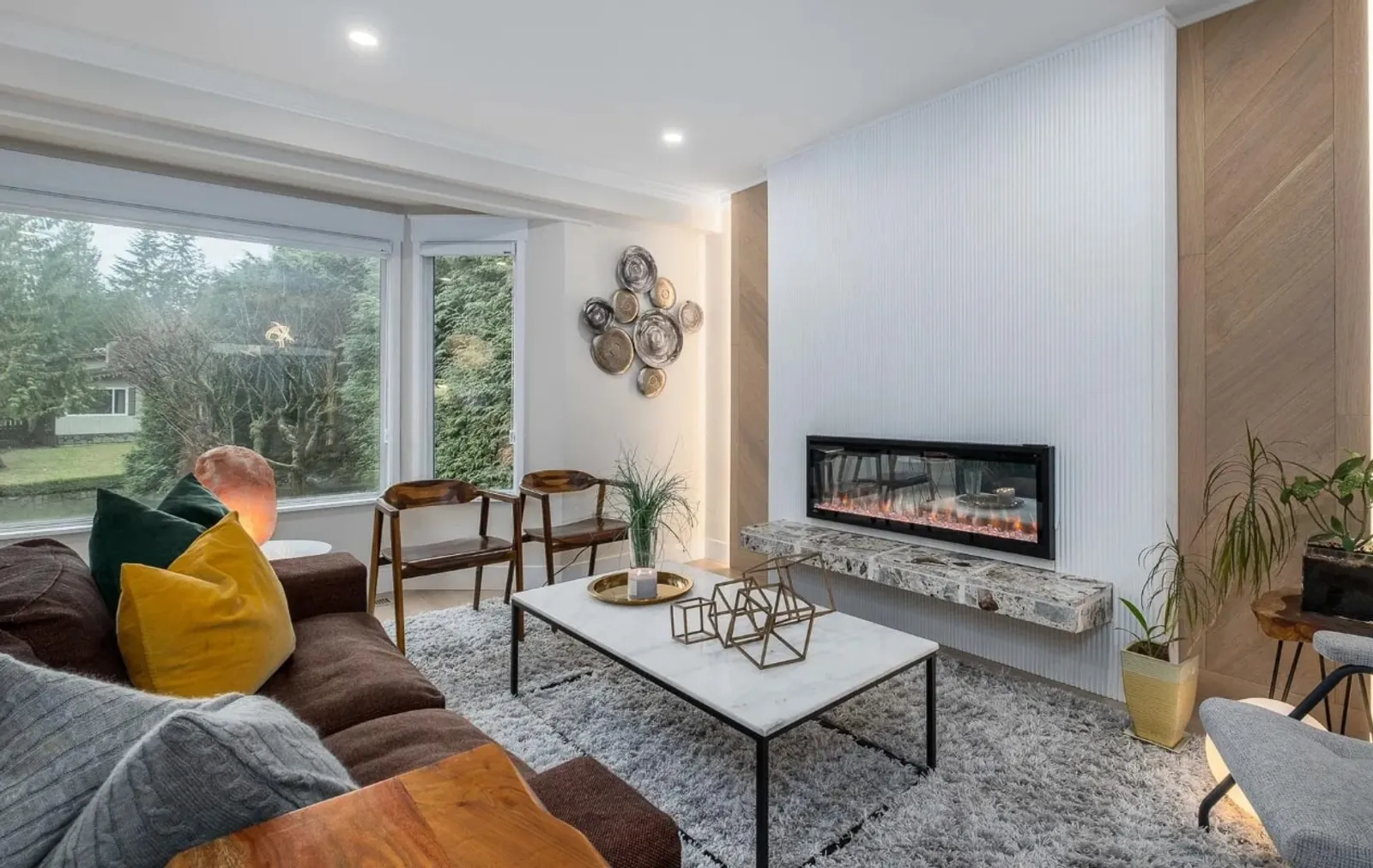 Modern living room after renovation with fluted panel accent wall, chevron wood pattern, and electric fireplace
