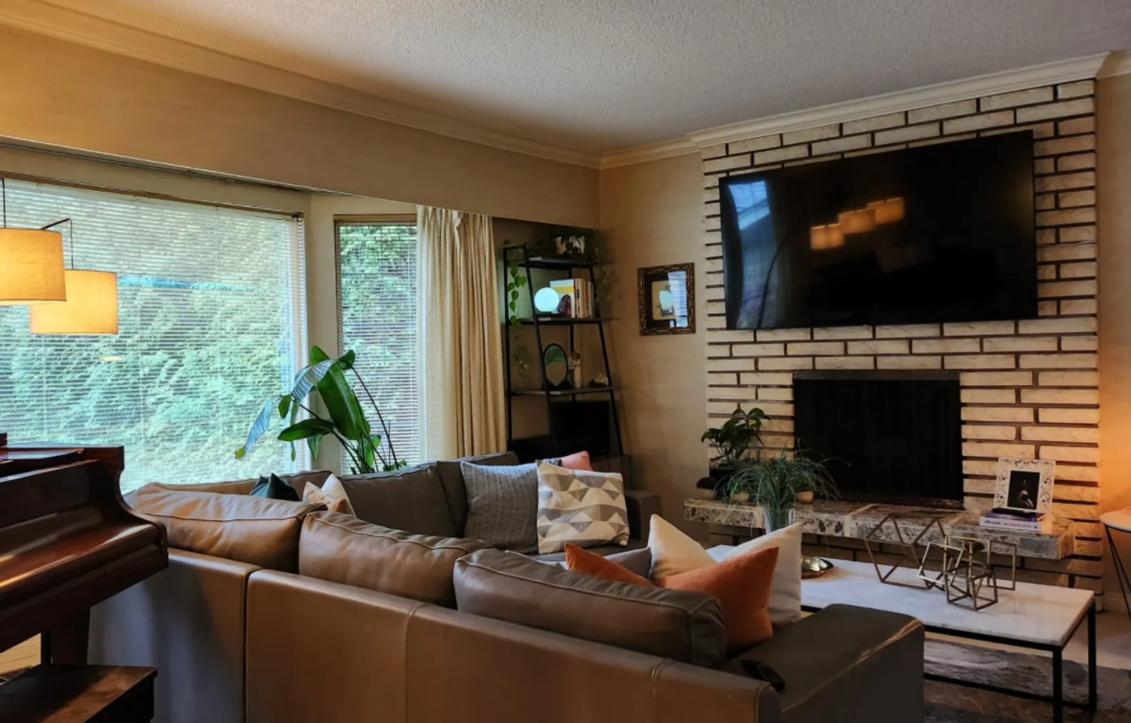 Living room before renovation with dated brick fireplace and beige walls